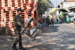Satpol PP Surabaya Sosialisasikan Penertiban di Bantaran Sungai Kali Tebu, Bantu Angkut Barang