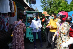 Bagikan Masker ke Pemukiman Warga, Risma Dibonceng Naik Motor