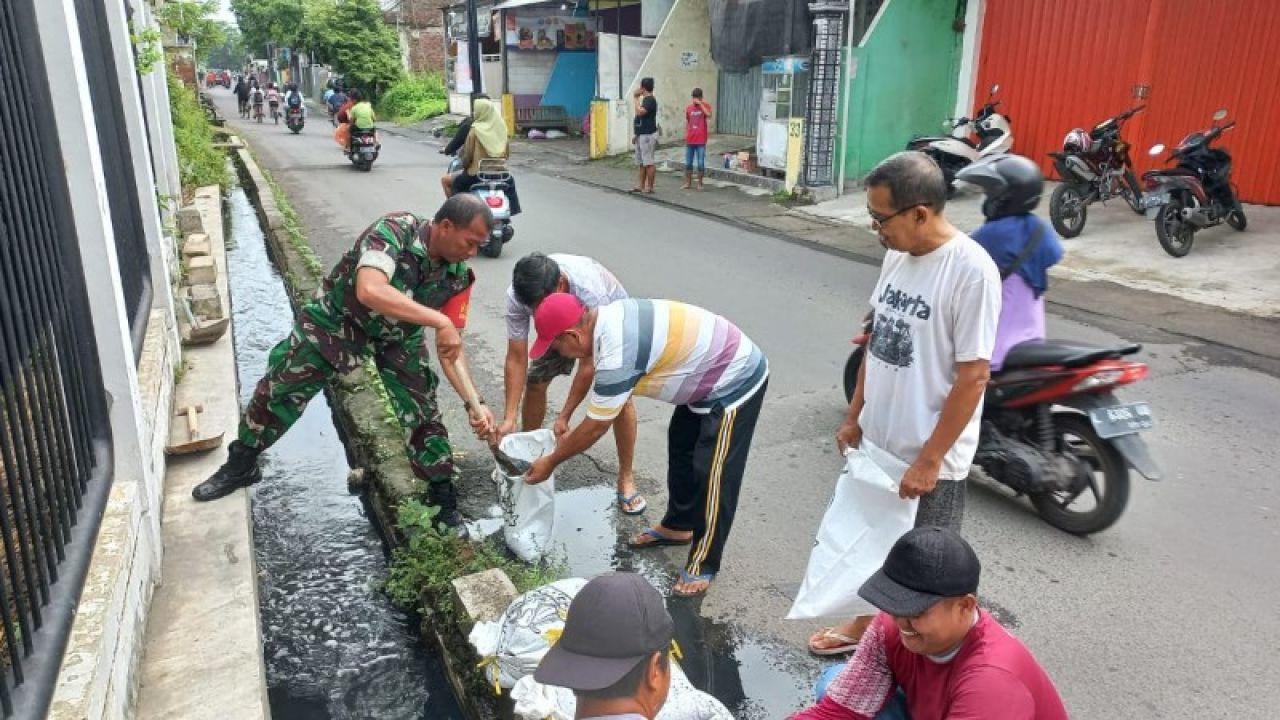 Babinsa Bersama Warga Karya Bakti Bersihkan Ruas Jalan dan Saluran Air
