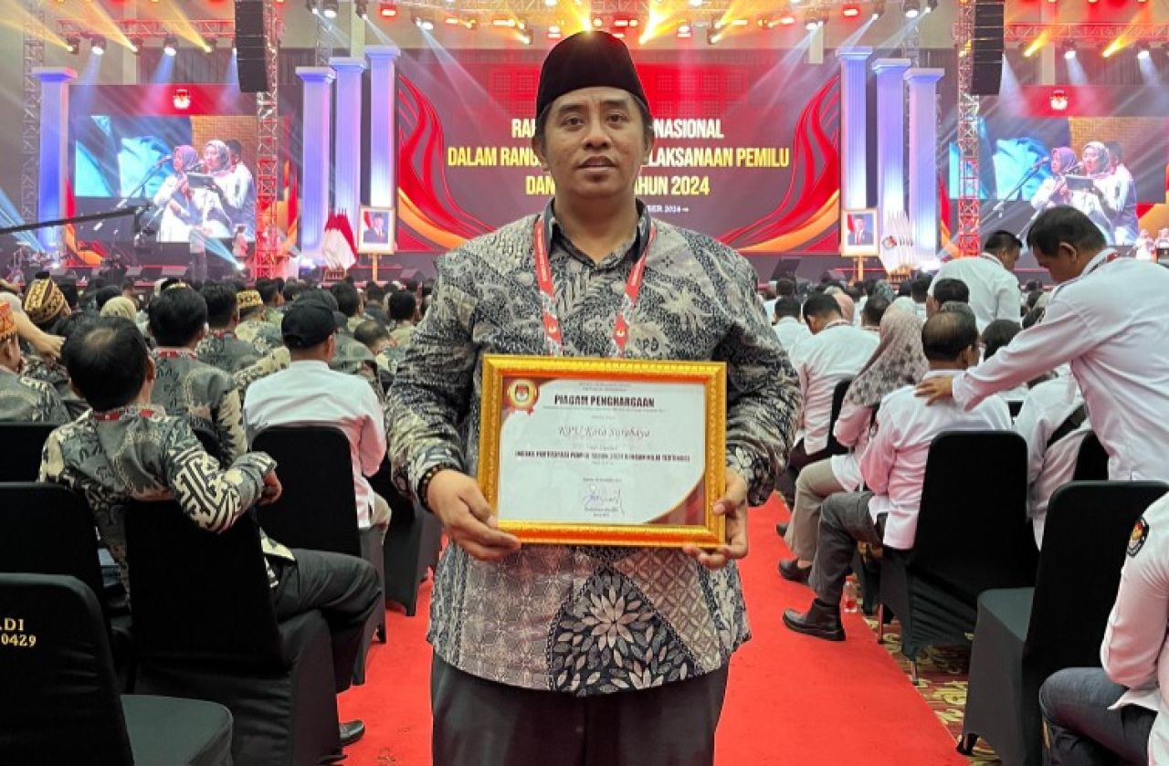Subairi, Komisioner KPU Kota Surabaya dengan salah satu piagam penghargaan di Konsolnas KPU RI. (Humas KPU Kota Surabaya)