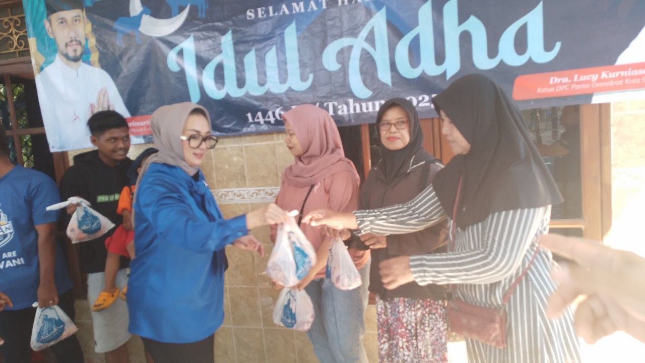 Lucy Kurniasari, Ketua DPC Partai Demokrat Kota Surabaya saat membagikan langsung paket daging kurban ke masyarakat. (Amar)