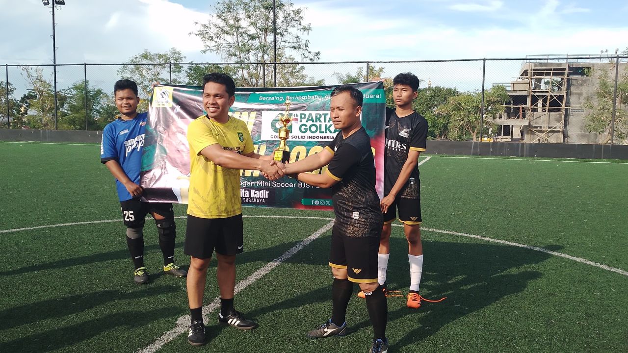 Eko Widodo Kapten Judes FC saat menerima piala juara 1 dari Hadi (DPD Partai Golkar Surabaya. (Amar)