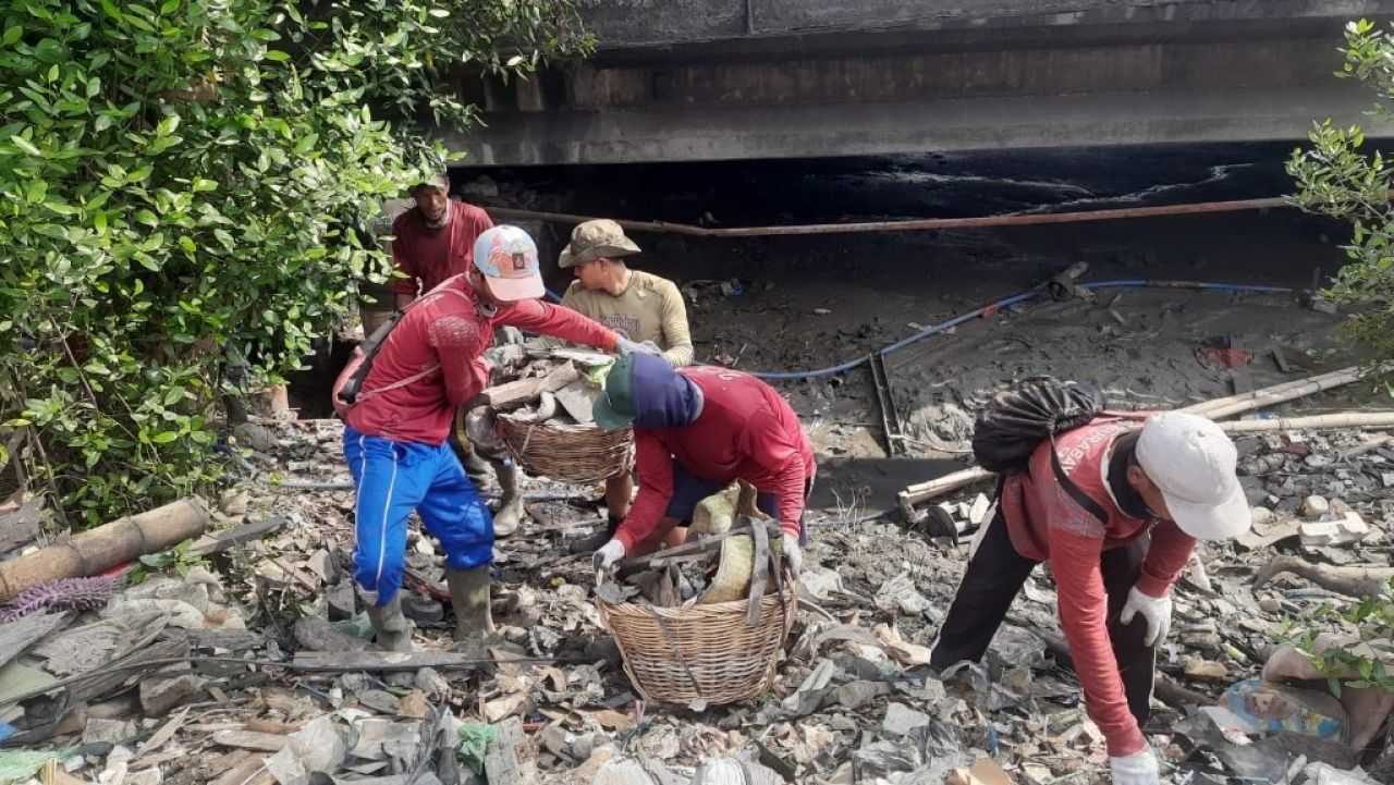 Petugas sedang membersihkan sampah di sungai (Kominfo Surabaya)
