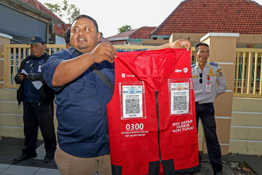 Petugas Dishub sedang menunjukkan rompi QRIS. (Kominfo Surabaya)