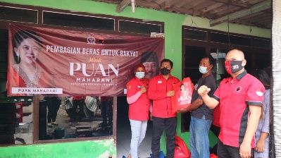 Abdul Ghoni dan kader PDI Perjuangan Surabaua saat membagikan beras . (dok. Mbesuel)
