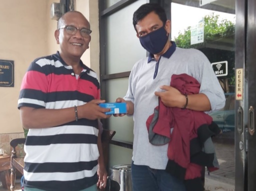 Sade (kiri) saat memberikan handphone ke Ndaru (kanan).