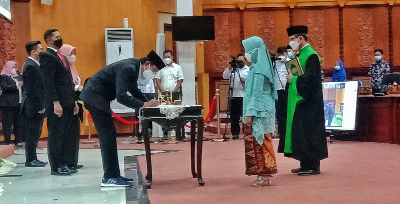 Ketua DPRD Kota Surabaya Adi Sutarwijono saat menandatangani naskah pelantikan dr Zuhrotul Mar'ah (kebaya hijau) sebagai Anggota FPRD Kota Surabaya. (Bachan) 