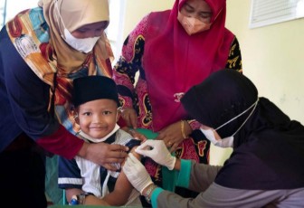Anugrah Ramadhan mendapat imunisasi di klinik yang terletak di desa tempat tinggalnya di Tanjung Pinang. UNICEF/Clark
