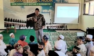 Ustadz Ashabul Kahfi di tengah para siswa SDN Sidotopo Wetan V Surabaya. (Adi)