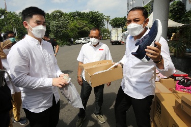 Eri Cahyadi (kanan) saat menunjukkan sepatu yang akan dikirim ke korban semeru, didampingi Armuji (tengah) di halaman Balaikota Surabaya. (dok. humas)